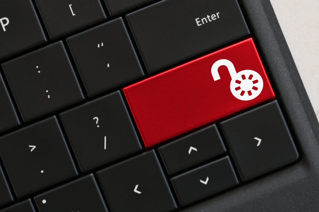 Computer keyboard with red key with open lock icon, security unsecured unlocked vulnerable concept