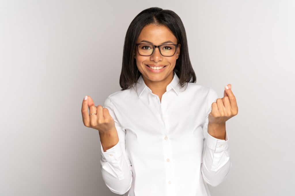 Successful smiling businesswoman does money gesture with fingers ask for investment, payment, salary