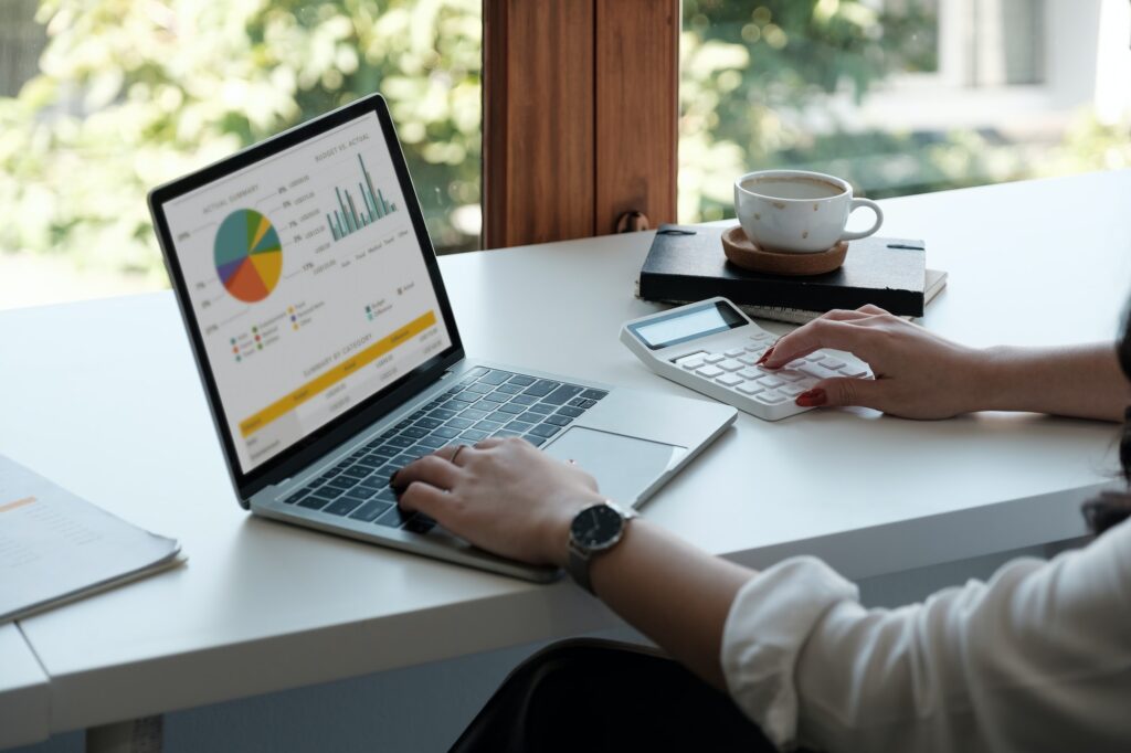 Businesswoman using calculator and laptop for calaulating finance, tax, accounting, statistics and