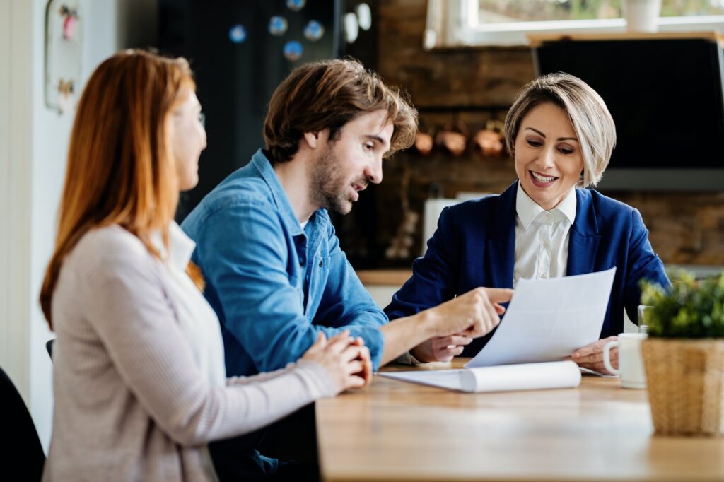 Financial advisor and young couple going through lease agreement on a meeting.