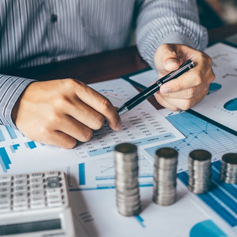 Businessman accountant making notes at report doing finances and calculate about cost of investment